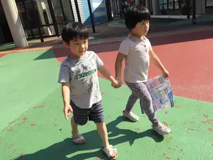 哥哥和姐姐牽著手走過彩色地坪，兄妹同遊 OUTLET，當時還在念幼稚園。
